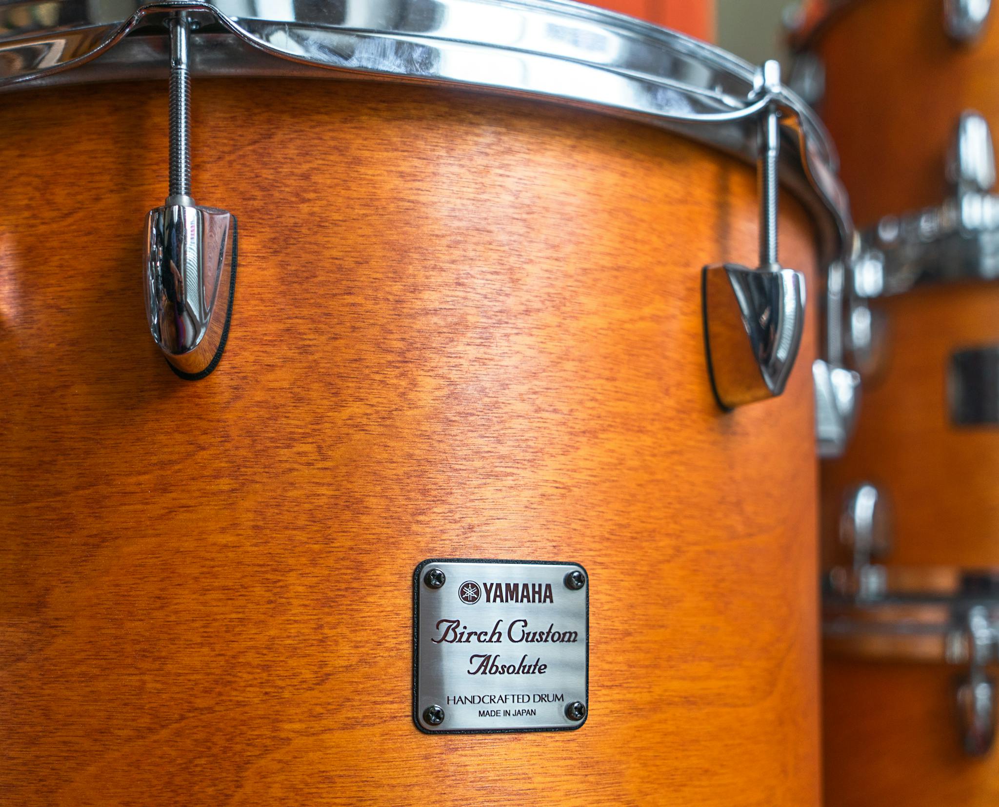Detailed close-up of a wooden birch custom drum set, showcasing craftsmanship.